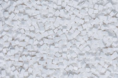 Rafine şeker. Şeker küplerinden desenli beyaz arka plan. Geri ışık.