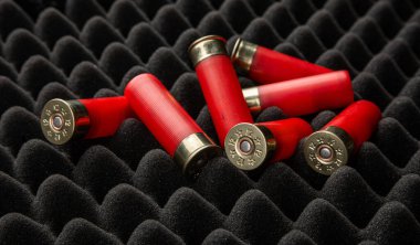 Köpük kauçuk üzerinde av tüfeği mermisi. 12 kalibrelik pürüzsüz silahlar için mühimmat. Cephanelik avlıyorum. Koyu arkaplan.