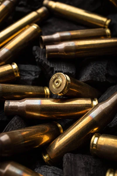 Silahlardan çıkan boş mermiler için yanan siyah kömürler. Savaşın sonuçları işte. Koyu arkaplan.