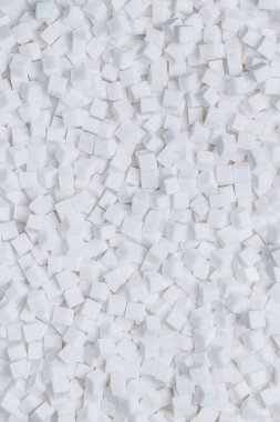 Rafine şeker. Şeker küplerinden desenli beyaz arka plan. Geri ışık.