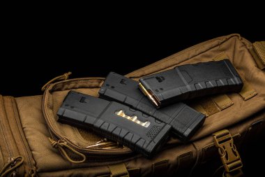 Tüfek ya da tüfek için şarjör ve şarjör. Silahlar için mühimmat. Silah mühimmatı askeri bir sırt çantasında. Koyu arkaplan.