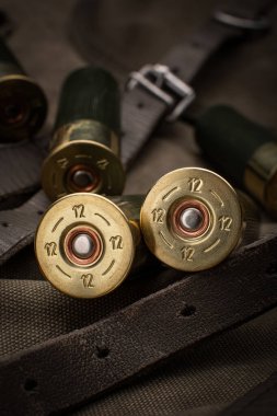 Pompalı mermiler yakın plan. Sırt çantasındaki haki rengi bez üzerinde yumuşak delikli silahlar için mühimmat. Koyu arkaplan.