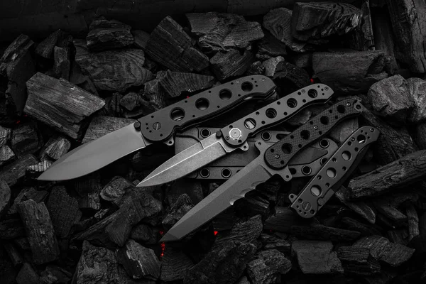 Modern Knives Black Blades Hunting Military Folding Knives Smoldering Charcoal — Stock Photo, Image