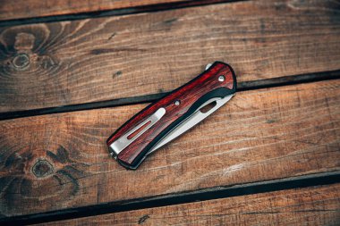 Ahşap saplı katlanmış çakı. Tahta yüzeyde küçük bir bıçak..
