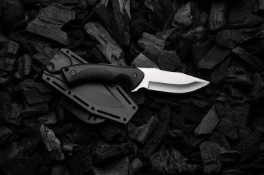 Gümüş bıçaklı modern bıçak. Avlanma, yanan kömürde askeri bıçak. Siyah arkaplan.