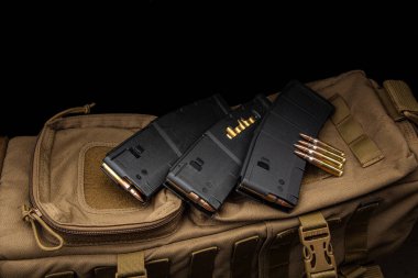 Tüfek ya da tüfek için şarjör ve şarjör. Silahlar için mühimmat. Silah mühimmatı askeri bir sırt çantasında. Koyu arkaplan.