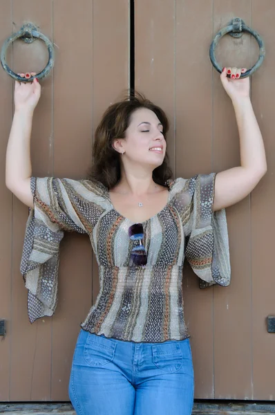 Vrouw houdt ijzeren ringen op houten deuren — Stockfoto