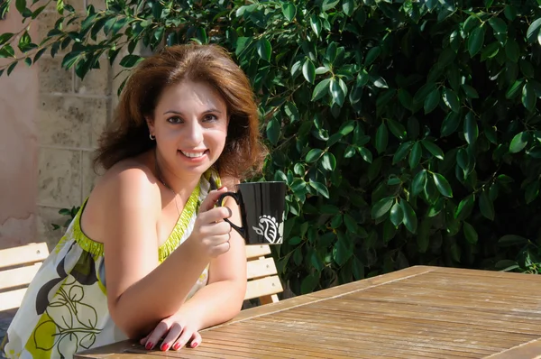 Mulher bonita sentada em um café bebendo café — Fotografia de Stock