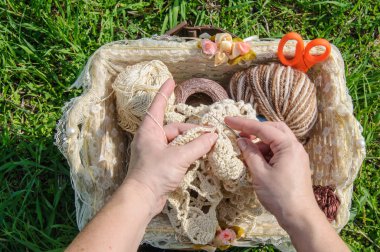 Close-up of  woman's hands crocheting outdoors clipart