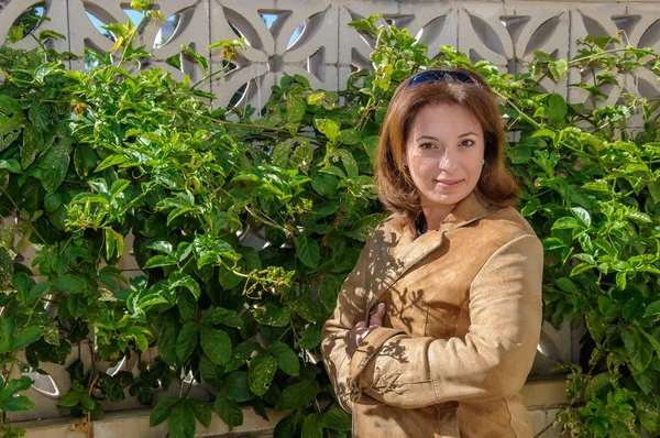 Mulher bonita nova em um contexto de folhas verdes — Fotografia de Stock