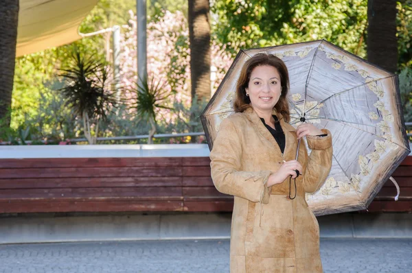 Mulher bonita em um parque com guarda-chuva — Fotografia de Stock