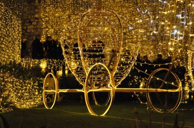 Parkta ışıklandırılmış Noel Arabası dekorasyonu. Hırvatistan 'ın Rijeka kentinde Noel ışıklandırma süslemeleri. Tel ve ışıktan yapılmış Noel masalı.