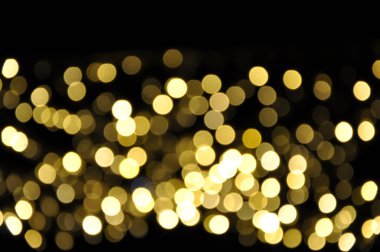 Siyah arkaplanda soyut bir bokeh. Yaratıcı, parlak, bulanık, altın bokeh duvar kağıdı. Yeni yıl, Noel ve kutlama konsepti