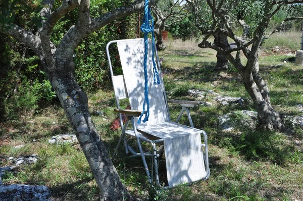 Folding chair camping is located in the garden on the grass on a Sunny summer day. old summer camping chair.