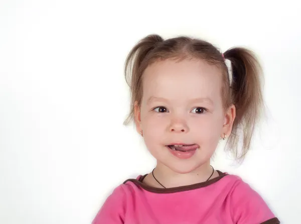 Cute little girl is licking her lips — Stock Photo, Image