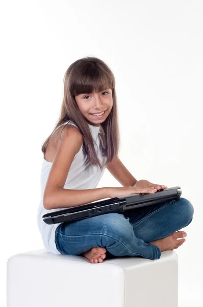Petite fille mignonne est assis avec ordinateur portable — Photo