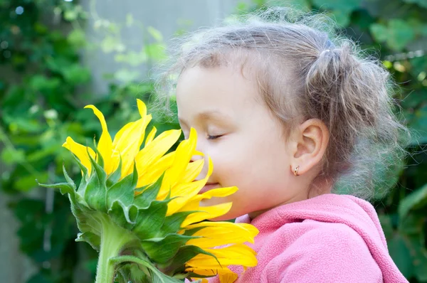 Beautiful little girl and sunflower — Stock Photo, Image