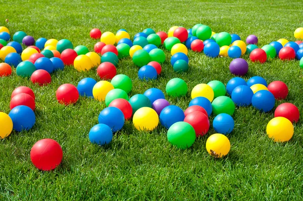 在绿色草地上的彩色球的堆 — 图库照片