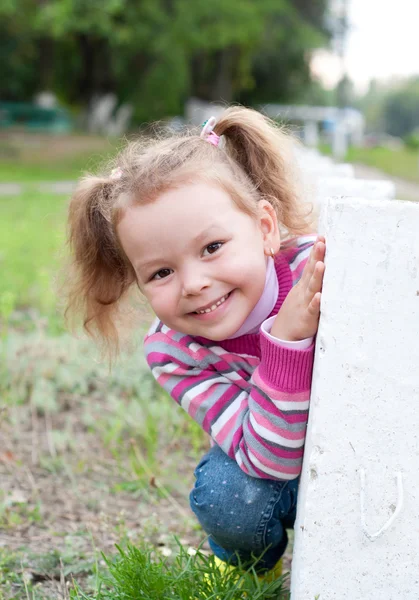 Cute dziewczynka gra Ukryj i szukać na zewnątrz — Zdjęcie stockowe