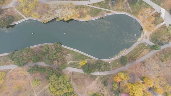 Sonbaharda şehir parkında yürüyüş ve patikalar. Yaprak parkta düşer. Sonbahar Gölü. Hava görünümü