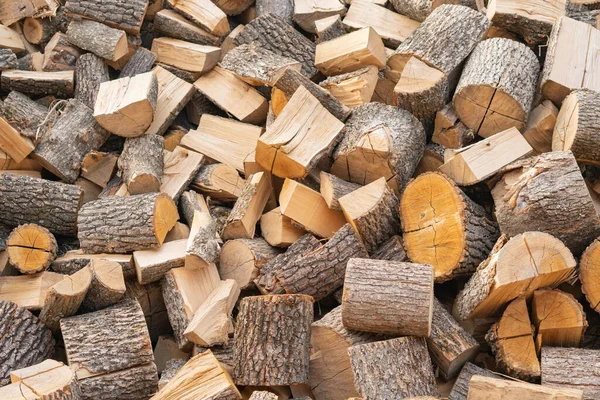 Dry sawn logs for firewood in a pile outdoors. Creative vintage background