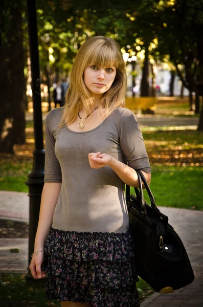 Portrait of girl with a black purse. — Stock Photo, Image