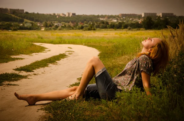 Mooi meisje ligt aan de rand van de weg — Stockfoto