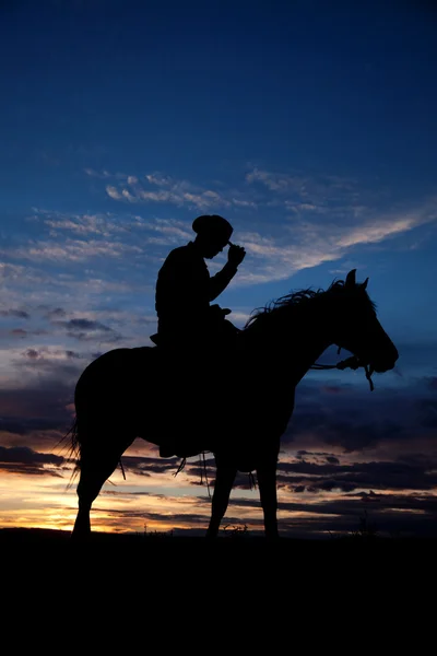 Vaquero sosteniendo sombrero caballo puesta del sol —  Fotos de Stock