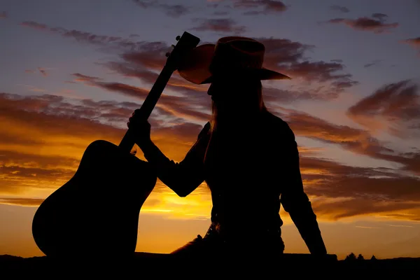 Mujer mantenga la guitarra en silueta lateral —  Fotos de Stock