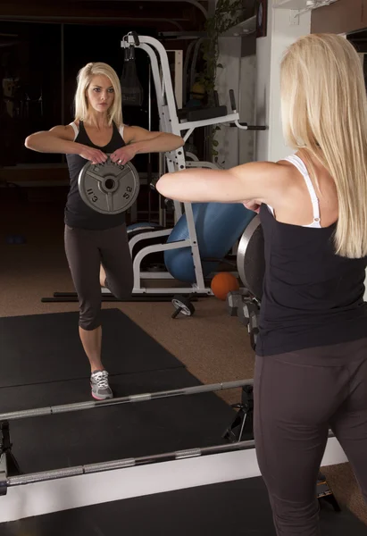 Woman holding weight in mirror — Stock Photo, Image