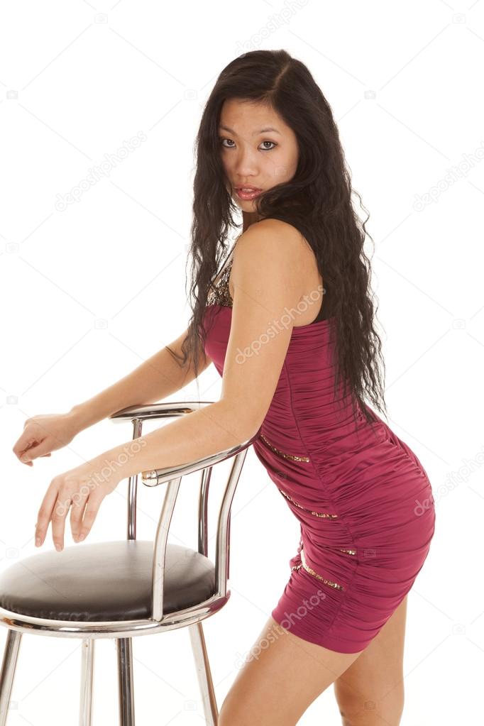 Asian woman red dress lean on chair