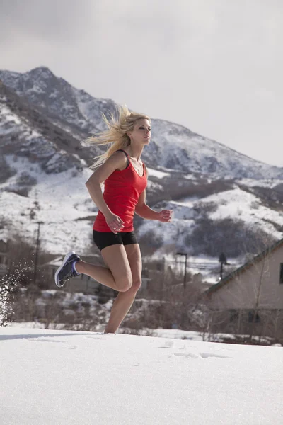 Woman fitness red run in snow — Stok fotoğraf