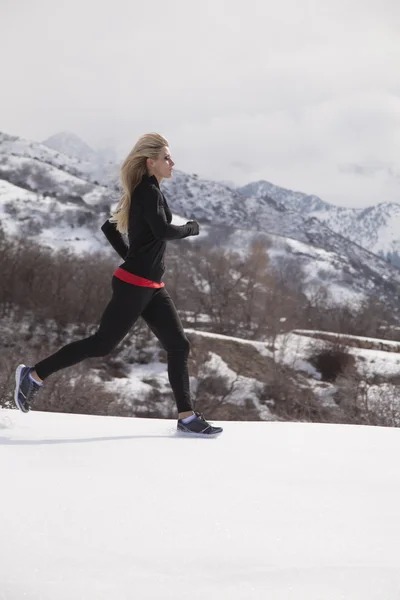 Femme jogging dans la neige — Photo