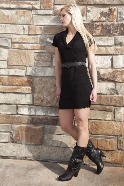 Frau schwarzes Kleid Felswand Blick nach unten — Stockfoto