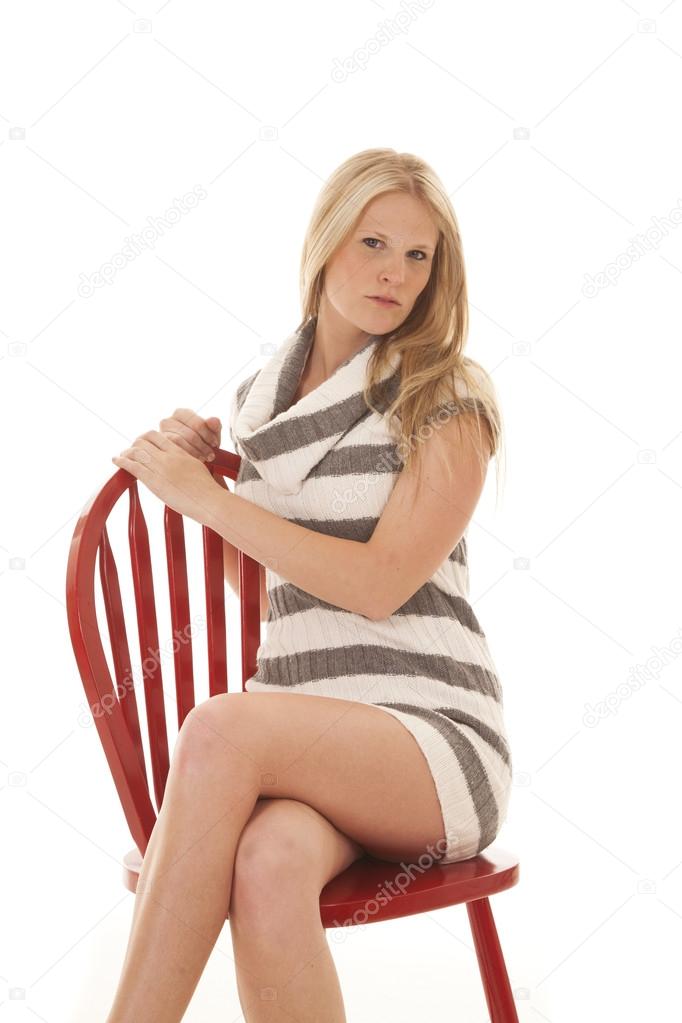 woman sit on red chair striped dress