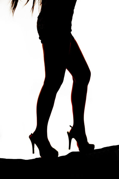 A silhouette of a woman walking up a hill.