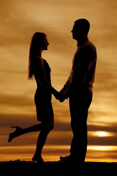 Silhouette couple stand together her leg up — Stock Photo, Image