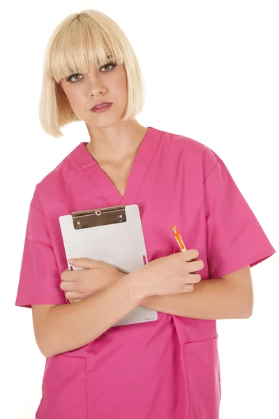 Медсестра в рожевих скрабах тримає блокнот — стокове фото