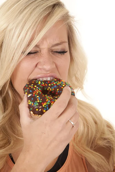 Mulher mordendo em um donut — Fotografia de Stock