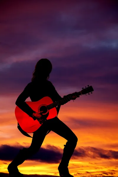 Uma mulher com uma guitarra ao pôr-do-sol . — Fotografia de Stock