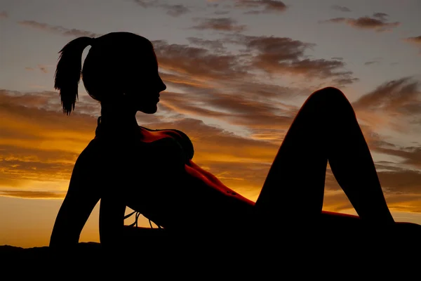 Silhouette of a woman in a bikini on elbows let up — Stock Photo, Image