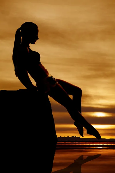 Silhouette woman touch toe in water sunset — Stock Photo, Image