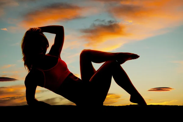Silhouette of a woman sitting back on elbow — Stock Photo, Image