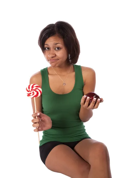 Mujer tratando de decidir sobre ser saludable o no ser saludable — Foto de Stock