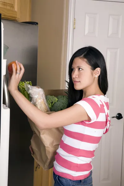 Vrouw haar boodschappen opbergen — Stockfoto