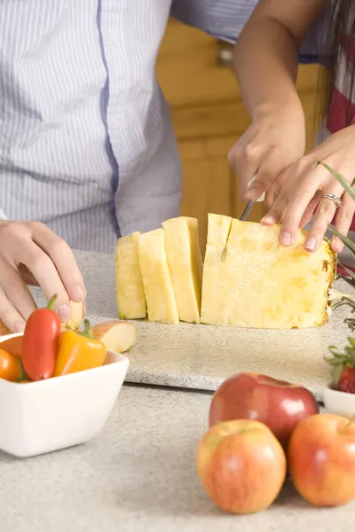 Vrouw snijden een ananas — Stockfoto