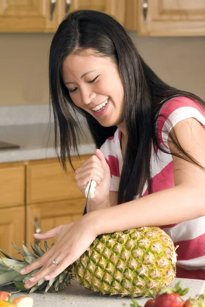 Frau schneidet eine Ananas — Stockfoto
