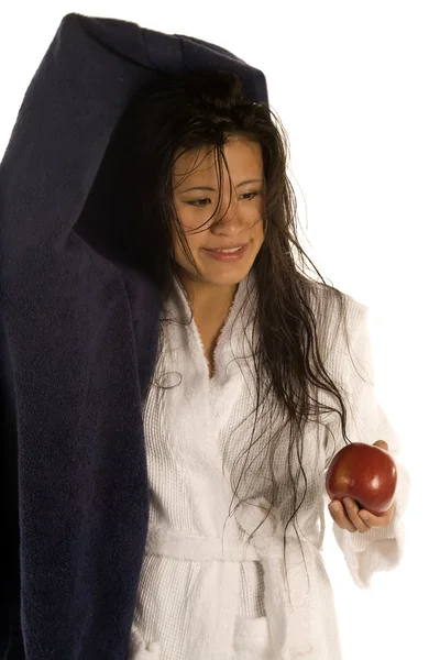 Woman drying her hair while enjoying an apple. — Stock Photo, Image