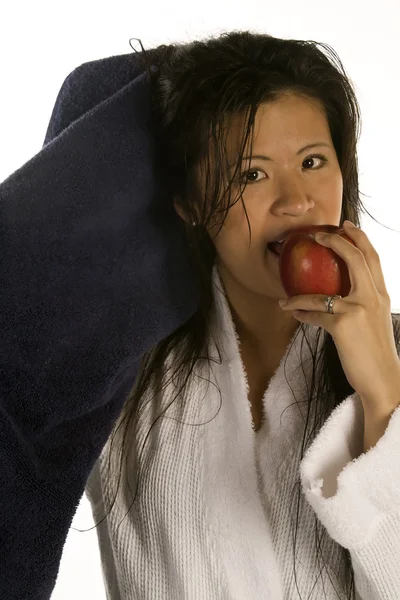 Mujer secándose el pelo mientras disfruta de una manzana . — Foto de Stock