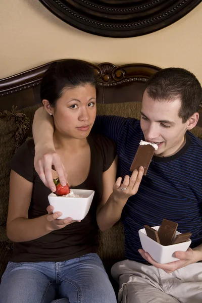 Mujer alimentando a su hombre una barra de chocolate — Foto de Stock